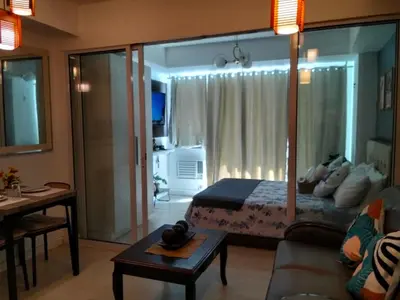 a bedroom with a bed and a living room at A&A staycation in Manila