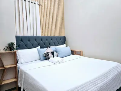 a bedroom with a large bed with a blue headboard at 3BR, 5 Beds, With Pool, Wifi, Netflix, Parking in Manila