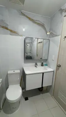 a bathroom with a toilet and a sink and a mirror at 3BR, 5 Beds, With Pool, Wifi, Netflix, Parking in Manila