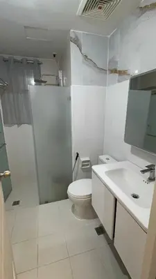 a white bathroom with a toilet and a sink at 3BR, 5 Beds, With Pool, Wifi, Netflix, Parking in Manila