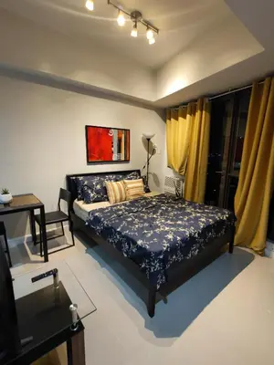 a bedroom with a bed and yellow curtains at Lowest Room Rate in Makati with fast wifi & view in Manila