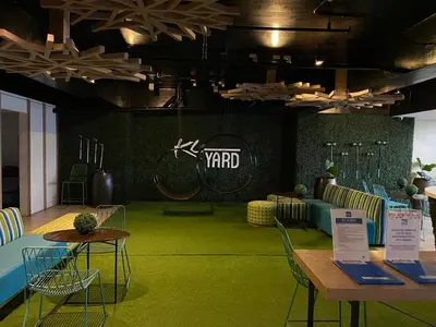 a room with green carpet and tables and chairs at Lowest Room Rate in Makati with fast wifi & view in Manila