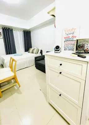 a bedroom with a bed and a dresser in a room at Jazz Residences Condo in Manila