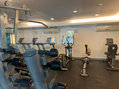 a gym with several tread machines in a room at Jazz Residences Condo in Manila
