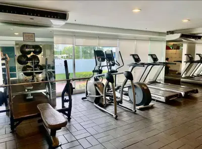 a gym with treadmills and exercise bikes in a room at Jazz Residences Condo in Manila