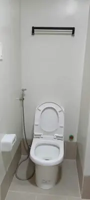 a bathroom with a white toilet with a hose at Condotels by Versola in Manila