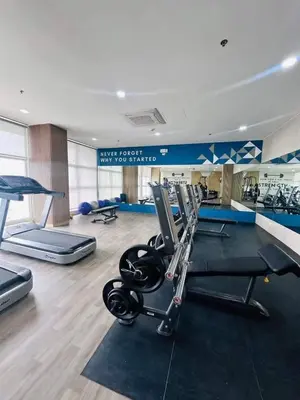 a gym with treadmills and weights in a room at Condotels by Versola in Manila