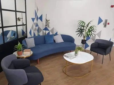 a living room with a blue couch and two chairs at Condotels by Versola in Manila