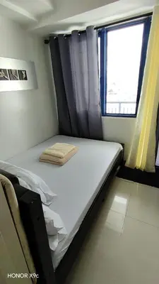 a bed in a room with a window at Sea Residences condotel in Manila