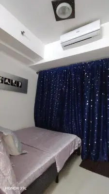 a bedroom with a bed with a blue curtain at Sea Residences condotel in Manila