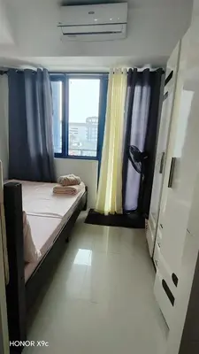 a small room with a bed and two windows at Sea Residences condotel in Manila