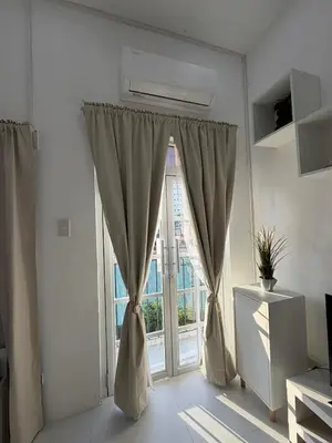 a living room with a large window with curtains at Ikea inspired home with mini balcony and free parking in Cainta