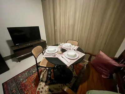 a room with a table with chairs and a television at Studio with Balcony, TV Netflix near Shaw MRT Station in Manila