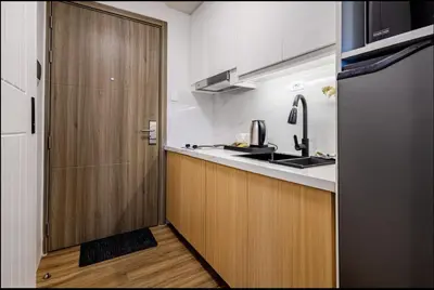 a kitchen with a wooden door next to a sink at EJs Crib Cozy 1BR Condo at SMDC Fame Residences in Manila
