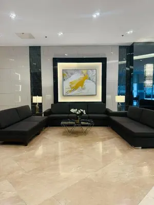 a living room with black couches and a painting at EJs Crib Cozy 1BR Condo at SMDC Fame Residences in Manila