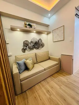 a living room with a couch in a room at EJs Crib Cozy 1BR Condo at SMDC Fame Residences in Manila