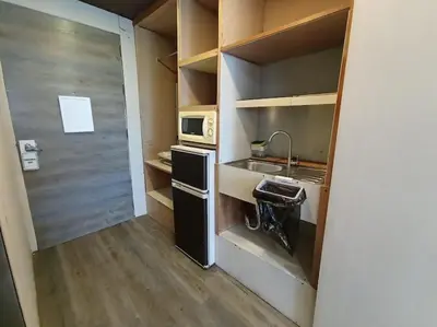 a small kitchen with a sink and a microwave at Benedict's Staycation in Manila
