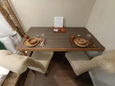 a wooden table with plates and napkins on it at Benedict's Staycation in Manila