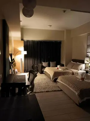 a hotel room with two beds and a desk at Spacious Studio 3B C5 in Manila