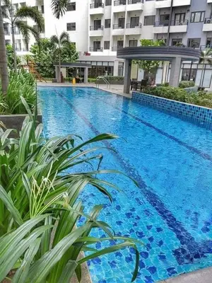 a large blue swimming pool in front of a building at Casa Kanlungan at Spring Residences Tower 3 in Manila