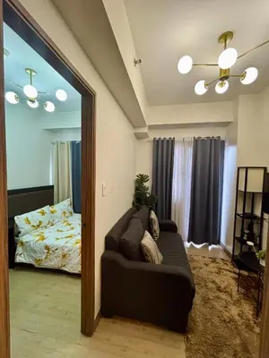 a living room with a couch in front of a mirror at Casa Kanlungan at Spring Residences Tower 3 in Manila