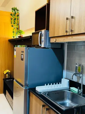 a kitchen with a refrigerator and a sink at Melscape Lush Residence 1BR Unit in Sampong