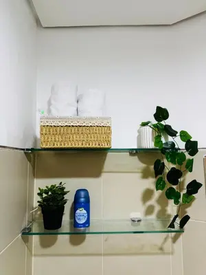 a glass shelf with towels and plants on it at Melscape Lush Residence 1BR Unit in Sampong