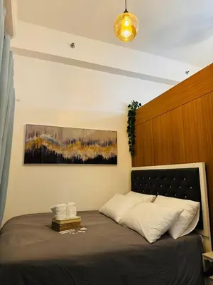 a bedroom with a bed with a painting on the wall at Melscape Lush Residence 1BR Unit in Sampong