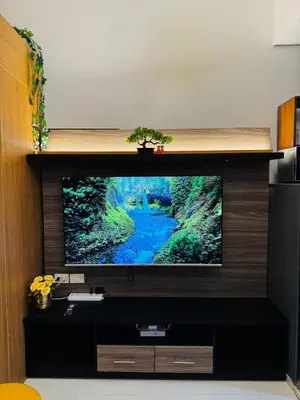 a flat screen tv sitting on top of a entertainment center at Melscape Lush Residence 1BR Unit in Sampong