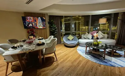 a living room with a table and chairs and a living room at Luxe 1BR Panorama Suite at Novotel Aqua in Manila
