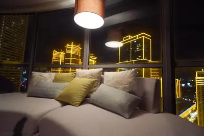 a couch in a room with a window with a city at Luxe 1BR Panorama Suite at Novotel Aqua in Manila