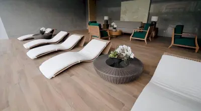 a living room with white chairs and a table at Melscape Lush Residence 1BR Unit in Manila