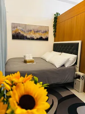 a bedroom with a bed with a sunflower in the foreground at Melscape Lush Residence 1BR Unit in Manila