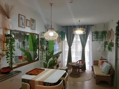 a living room with a table and some plants at Raku Home - Urban Resort Living in Manila