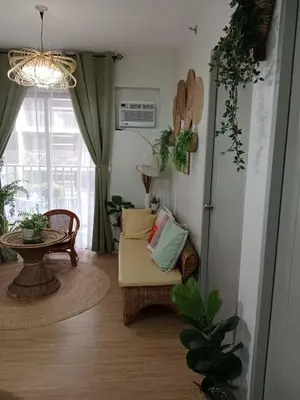 a living room with a chair and a table at Raku Home - Urban Resort Living in Manila