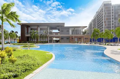 a large swimming pool in front of a building at Raku Home - Urban Resort Living in Manila
