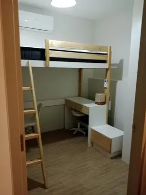 a room with a desk and a bunk bed at Raku Home - Urban Resort Living in Manila