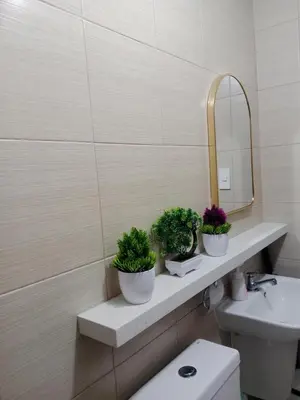 a bathroom with three potted plants on a shelf at Raku Home - Urban Resort Living in Manila