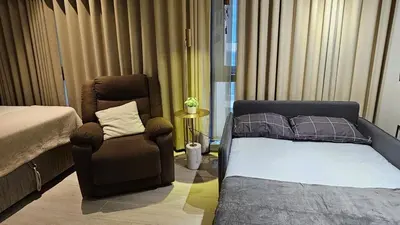 a bedroom with a bed and a chair and a bed and a couch at One Bedroom Premier at Eastwood Global Plaza Luxury Residences in Manila