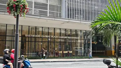 a person riding a motorcycle in front of a building at One Bedroom Premier at Eastwood Global Plaza Luxury Residences in Manila