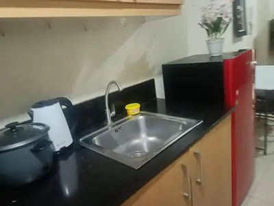 a kitchen counter with a sink and a appliance at Sea Residences peya in Manila