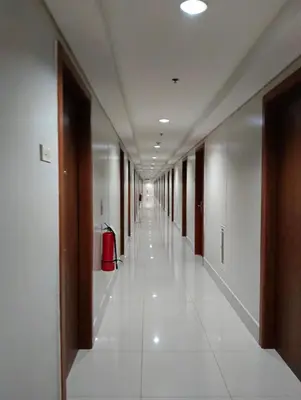 an empty hallway of an office building with a long corridor at Sea Residences peya in Manila