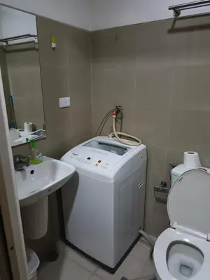 a bathroom with a washing machine and a sink at Shore Recidences Mall Of Asia Chullen in Manila