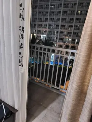 a balcony with a view of a large building at Shore Recidences Mall Of Asia Chullen in Manila