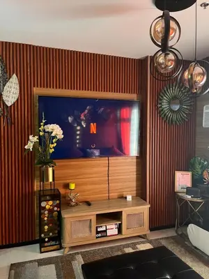 a living room with a large flat screen tv at Modern 1BR Condo in Pasay With Balcony City View Free Swimming Pool Near NAIA Airport, PICC, CCP, MOA in Manila