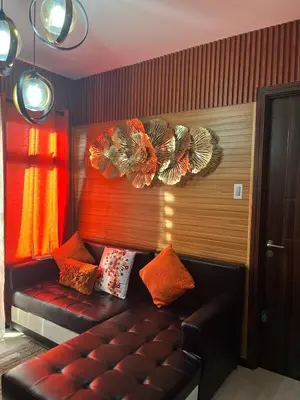 a living room with a leather couch with pillows at Modern 1BR Condo in Pasay With Balcony City View Free Swimming Pool Near NAIA Airport, PICC, CCP, MOA in Manila