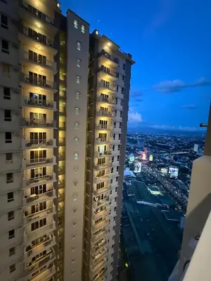 a view of two tall buildings at night at Cozy Home with a great view in Manila