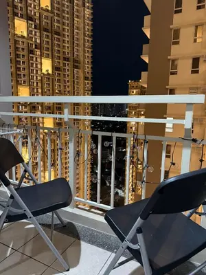 two chairs on a balcony with a view of a city at Cozy Home with a great view in Manila