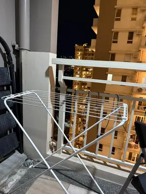 a white chair on a balcony with a view of a city at Cozy Home with a great view in Manila