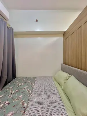a small bedroom with a bed and a curtain at Airport-side Shore Staycation in Manila